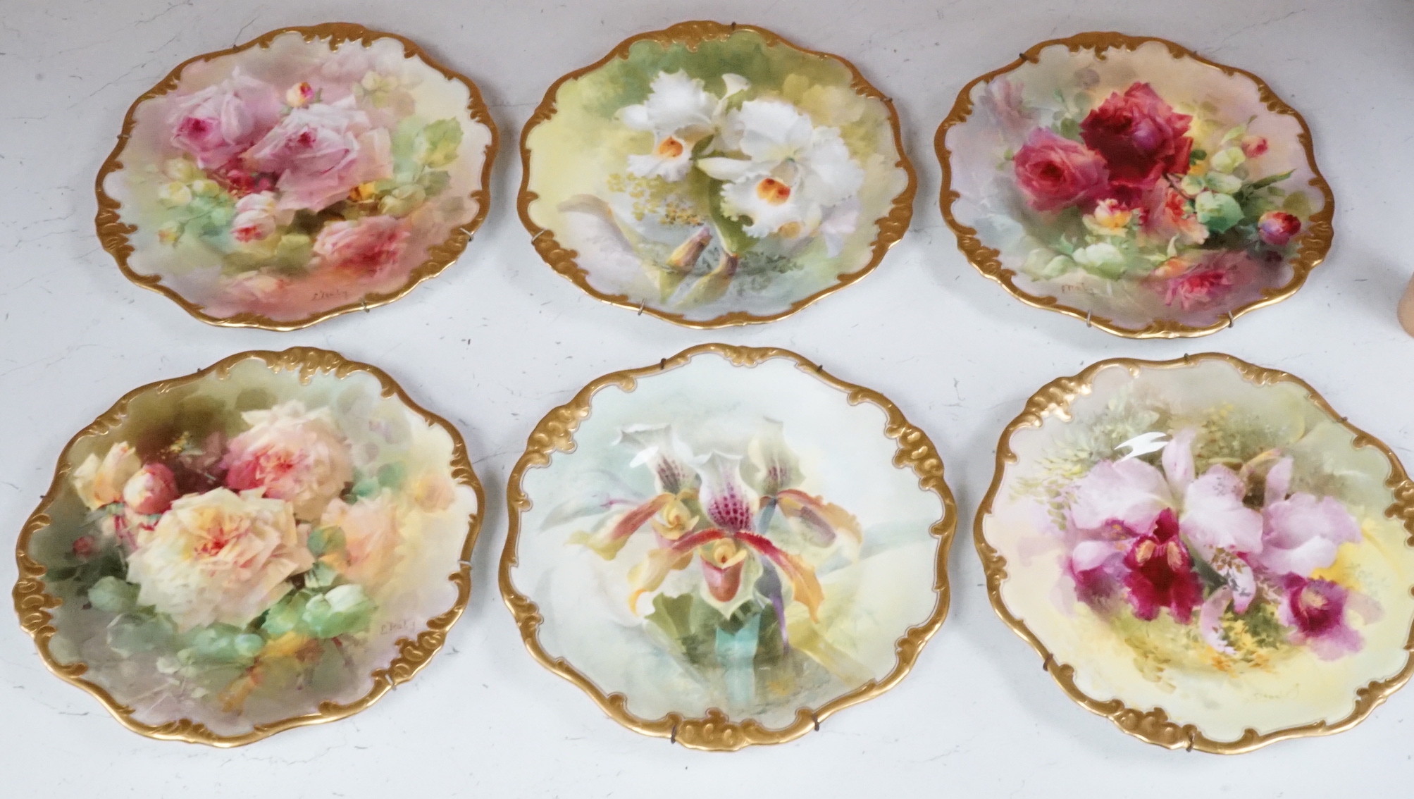 Six Royal Doulton floral painted plates, three signed E. Raby and three signed D. Dewsberry